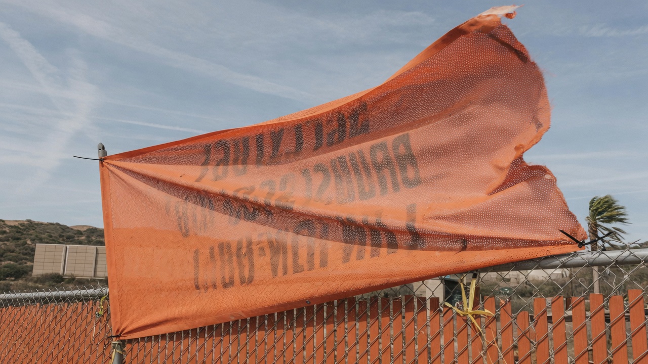 Mesh construction fence banner in Orange County wind